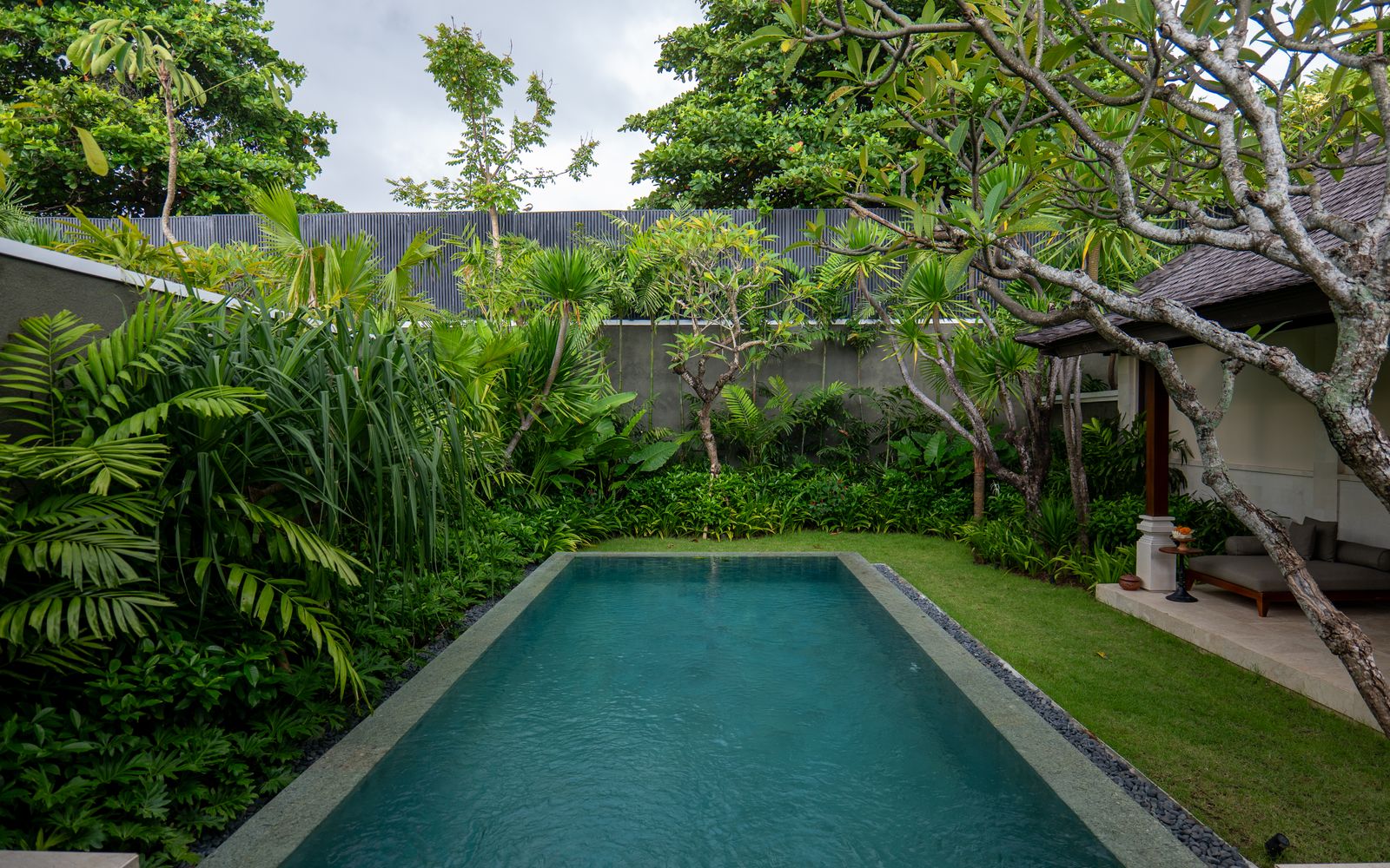Luxurious villa pool surrounded by lush tropical greenery in Bali, Indonesia.
